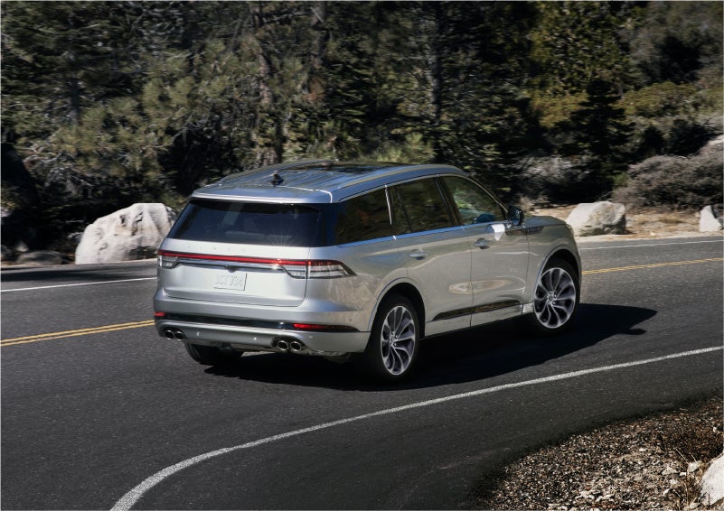 A 2023 Lincoln Aviator® Grand Touring model is shown being driven on a tight turn of a mountain road | George Ballentine Lincoln in Greenwood SC