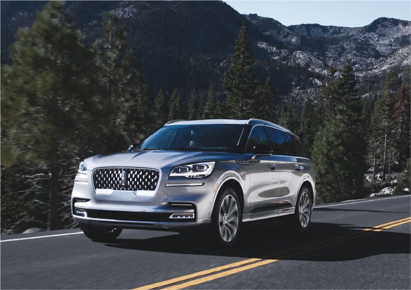 A 2023 Lincoln Aviator® Grand Touring SUV being driven on a winding road to demonstrate the capabilities of all-wheel drive | George Ballentine Lincoln in Greenwood SC