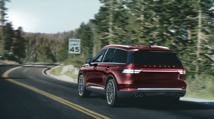 A 2024 Lincoln Aviator® SUV is being driven on a winding mountain road | George Ballentine Lincoln in Greenwood SC