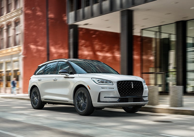 The 2024 Lincoln Corsair® SUV with the Jet Appearance Package and a Pristine White exterior is parked on a city street. | George Ballentine Lincoln in Greenwood SC